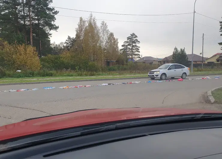 В Лесосибирске неизвестные раскладывают одежду посреди дороги рядом с кинотеатром «Луч»