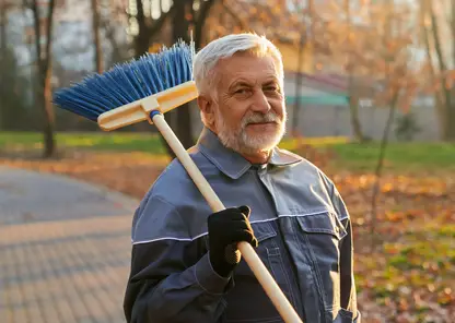 ulybausiisa-rabocii-muzcina-smotrasii-v-kameru-derza-metlu-na-plece-portret