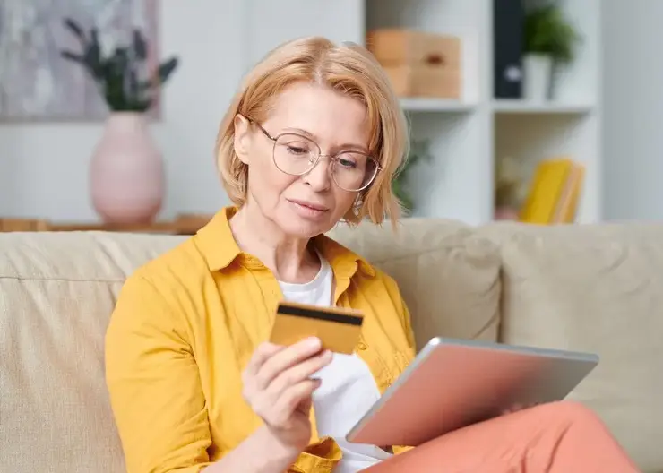 mature-blond-woman-eyeglasses-casualwear-looking-credit-card-while-going-online-shopping-home-quarantine_274679-13614